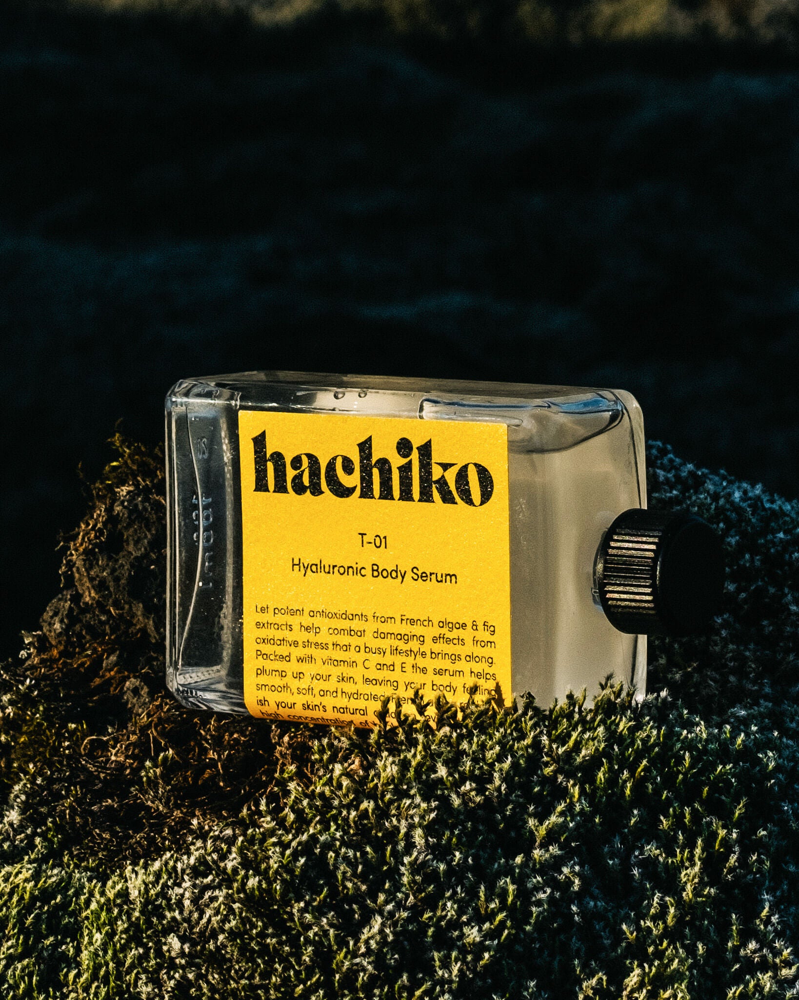 T-01 Hyaluronic Body Serum liegt im Sonnenlicht in grüner Natur