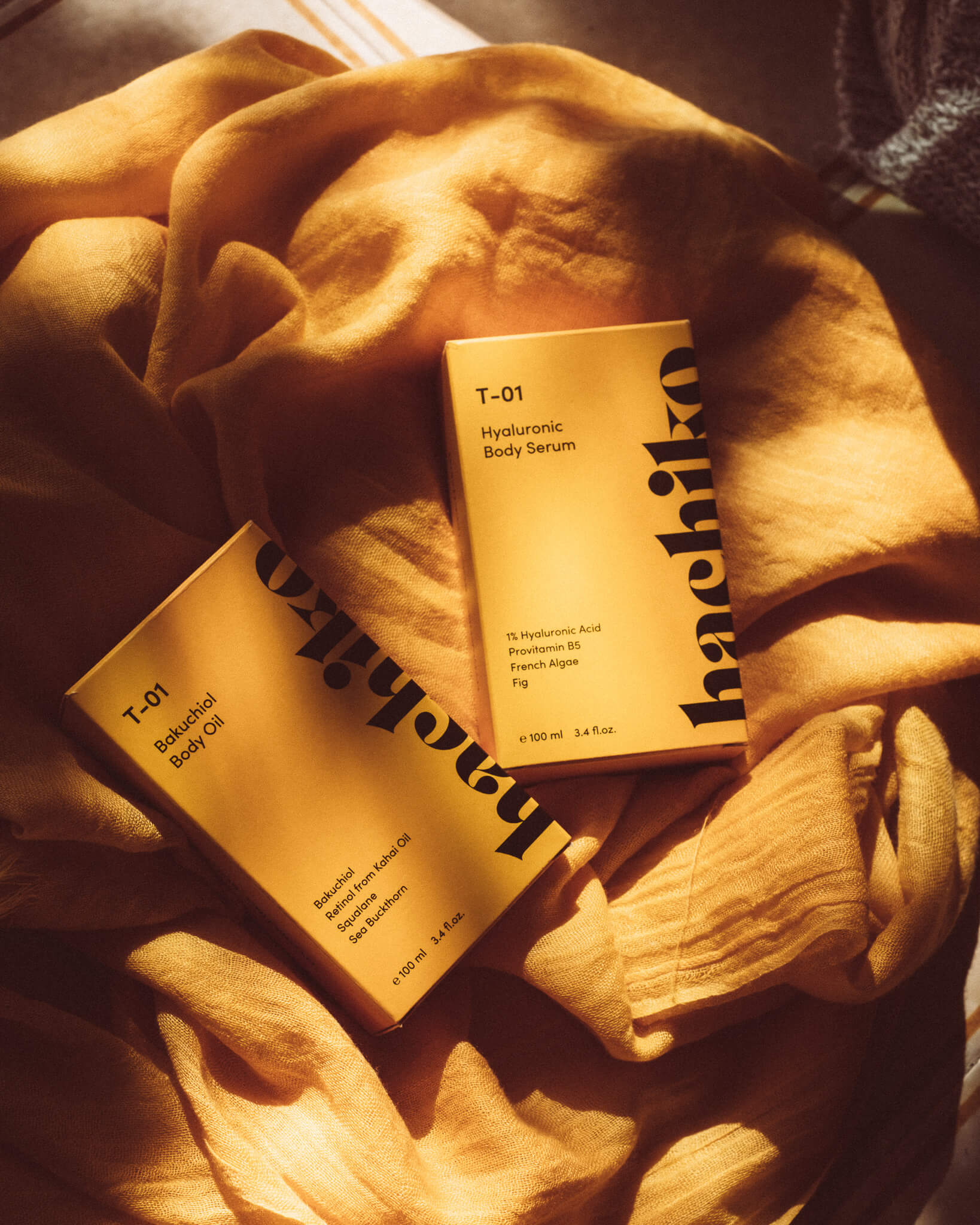 hachiko Berlin T-01 Body Treatment auf gelbem Tuch im Sonnenlicht 